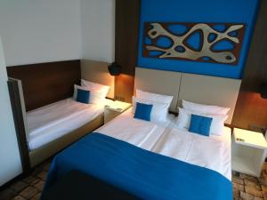 una habitación de hotel con 2 camas y un cuadro en la pared en Turm Hotel en Frankfurt