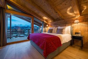 una camera da letto con un letto e una grande finestra di La Cordée des Alpes SUP a Verbier