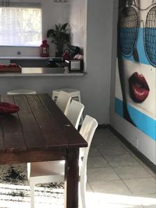 een eetkamer met een houten tafel en witte stoelen bij Tortilla no 3 in Bloemfontein