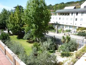 un jardin en face d'un bâtiment blanc dans l'établissement Gran Hotel Balneario, à Baños de Montemayor