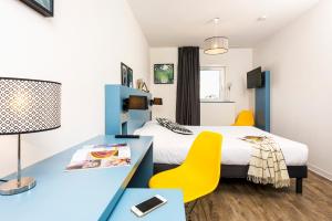 a hotel room with a bed and a desk with a desk at T&eacute;n&eacute;o Apparthotel Bordeaux - Gare Saint Jean in Bordeaux
