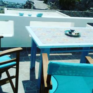 a blue table with a plate on it next to a chair at Serifos Summer Dream House in Serifos Chora