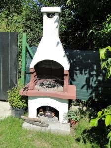 a outdoor pizza oven in a yard with a grill at Willa Sokołówka in Polanica-Zdrój
