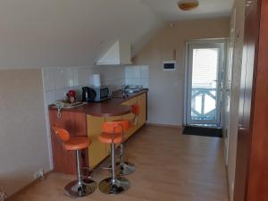 a small kitchen with a counter and stools in it at Gaspada in Sėlenai