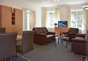 sala de estar con mesa y muebles de cuero marrón en Robert-Schuman-Haus, en Trier