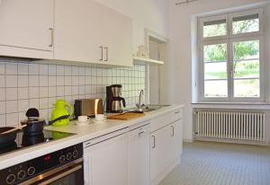 cocina con armarios blancos y fogones en Robert-Schuman-Haus, en Trier