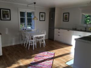 a kitchen and dining room with a table and chairs at Blommenshage in Grisslehamn