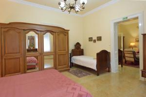 a bedroom with a bed and a large wooden cabinet at Apartman Vila Milica in Kikinda