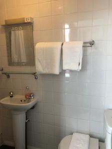 een badkamer met een wastafel, een toilet en handdoeken bij The Hunt Lodge in Leighton Buzzard