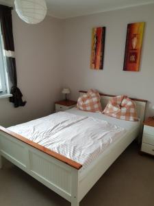Una cama blanca con dos almohadas encima. en Landhof-Erkner, en Erkner