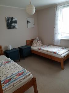 1 Schlafzimmer mit 2 Betten und einem Fenster in der Unterkunft Landhof-Erkner in Erkner