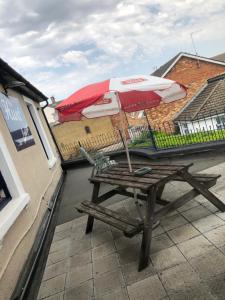 a picnic table with an umbrella on a balcony at The Hunt Lodge in Leighton Buzzard +19 photos