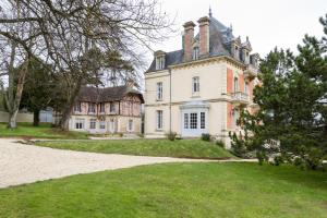 an old house with a turret and a yard at Les Villas d'Arromanches, Teritoria in Arromanches-les-Bains