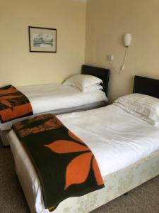 a hotel room with two beds and two lamps at The Hunt Lodge in Leighton Buzzard