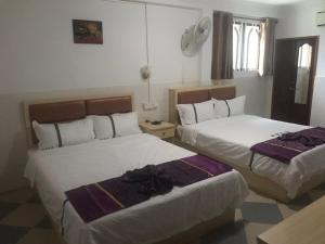 una habitación de hotel con 2 camas en una habitación en Don Bosco Guesthouse, en Sihanoukville