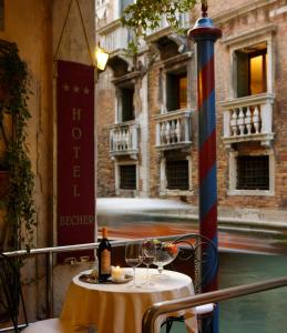 a table with glasses and a bottle of wine at Hotel Becher in Venice