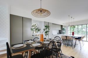 a dining room and kitchen with a table and chairs at L'Entre Deux Mers - Belle maison 8 personnes in Dinard