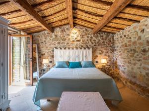 1 dormitorio con 1 cama grande en una pared de piedra en Angolo di paradiso sul mare, en Geremèas