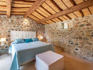 a bedroom with a bed and a stone wall at Angolo di paradiso sul mare in Geremèas