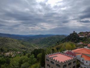 uma vista para uma cidade e montanhas com um edifício em Casas da Lagariça em Sortelha