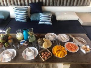 a table topped with plates of food on a couch at maison au zenit in Maceio