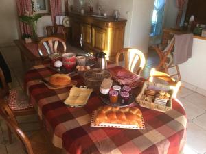 uma mesa com pequeno-almoço de pão e pastelaria em Chambre d’hôtes à Vallet em Vallet