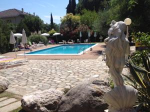 uma estátua de uma mulher ao lado de uma piscina em Loano Apartment Pool & Garden em Loano