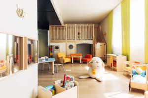 een kamer met een kinderkamer met een speeltuin bij harry's home hotel & apartments in München
