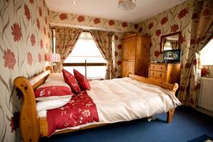 1 dormitorio con 1 cama grande con almohadas rojas en Evergreen Bed & Breakfast, en Swords