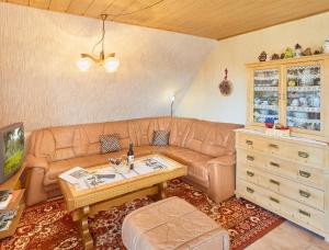 een woonkamer met een bruine leren bank en een tafel bij Ferienwohnung Haus Barbara in Bräunlingen