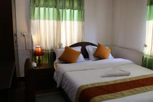 a bedroom with two beds and a lamp and a window at Kathmandu Peace Guesthouse in Kathmandu