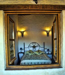 a reflection of a bedroom with a bed in a mirror at Apartamento Rural El Pino in Mogarraz
