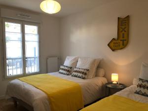 um quarto com duas camas e um relógio na parede em Coccon 1 By Dream Apartments em Serris