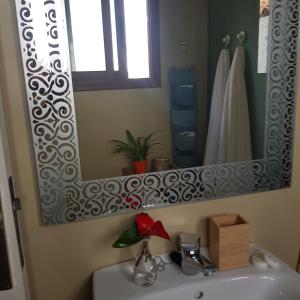 a bathroom with a sink with a large mirror at Elescondite in Sauzal