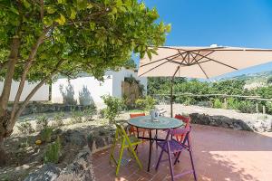a table and chairs with an umbrella on a patio at Nitrodi Thermal Relais in Ischia