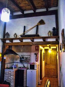 cocina con fogones y nevera blanca en Apartamento Rural El Pino, en Mogarraz