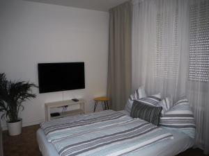 Un dormitorio con una cama y un televisor de pantalla plana. en APSTAY central station I Self Check-in I FREE Parking, en Graz