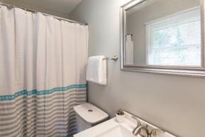 a bathroom with a sink and a toilet and a mirror at Luxury Home w/GameRoom KingSizeBed near Six Flags in Austell