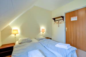 sypialnia z łóżkiem z niebieską pościelą i poduszkami w obiekcie Abild Kro & Hotel w mieście Tønder
