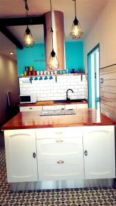a kitchen with white cabinets and a sink and lights at vinaros playa de arena in Vinarós