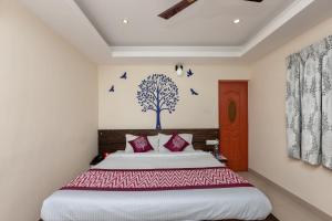 a bedroom with a bed with birds on the wall at Maruthi Residency in Chennai