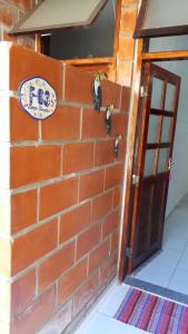 eine Backsteinmauer mit einem Schild an der Tür in der Unterkunft Apartamento em maranduba in Ubatuba