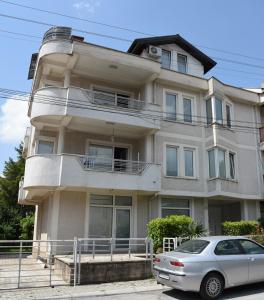 un coche blanco estacionado frente a un edificio en Mihail's Apartments in Ohrid - 2 en Ohrid
