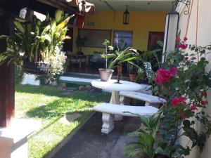 a patio with a table and some plants and flowers at Hotel Caleta in San Miguel