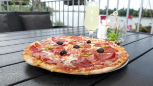 a pizza sitting on top of a wooden table at B&B Posejdon in Sremska Mitrovica
