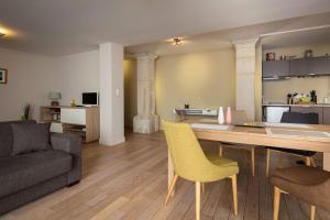 uma sala de estar com uma mesa e cadeiras amarelas em L'Aparté em Nancy