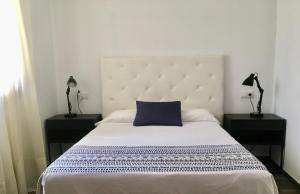 a bedroom with a large bed with a blue pillow at Apartamento La Güixa in Albir +13 photos