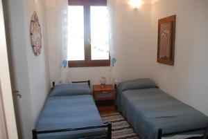 two twin beds in a room with a window at Attico La Murighessa in Castelsardo