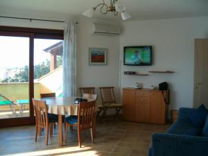 a living room with a table and chairs and a couch at Attico La Murighessa in Castelsardo