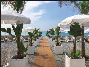 a pathway with plants and umbrellas on a beach at LOFT 360° Nice in Nice